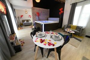 een woonkamer met een tafel en een kamer met een zwembad bij Eaudyssée maison avec SPA privée - Loiret in Ladon