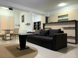 een woonkamer met een bank en een tafel bij Ferdinand Apartment in Constanţa