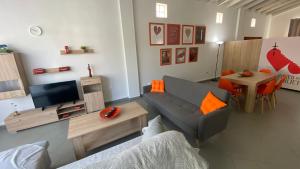 een woonkamer met een bank, een tv en een tafel bij Patras Romeο House in Patra