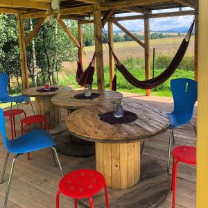 two tables and chairs on a wooden deck at Całoroczne jurty mongolskie - "Domy Słońca" in Kłodzko