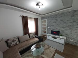 a living room with a couch and a tv at Guest house Vlahovic in Kolašin