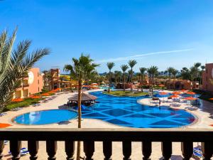 vistas a una piscina del complejo con palmeras y sombrillas en Nubian Village, Families and Couples only, en Sharm El Sheikh