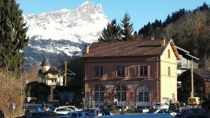 un edificio con una montaña cubierta de nieve en el fondo en Le Balcon des Aravis en Saint-Gervais-les-Bains