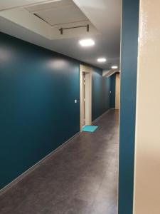 an empty hallway with a blue wall and a tile floor at Le Balcon des Aravis in Saint-Gervais-les-Bains