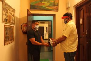 deux hommes debout dans un couloir portant des masques pour le visage dans l'établissement Casa Dos Rebelos, à Panaji