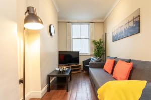 een woonkamer met een bank en een tv bij Camden City Living in Londen