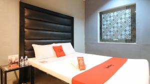 1 dormitorio con 1 cama con cabecero negro en RedDoorz @ P Florentino Street Sampaloc Manila, en Manila