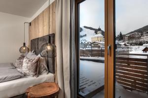 a bedroom with a bed and a sliding glass door at hager's apartments in Saalbach-Hinterglemm