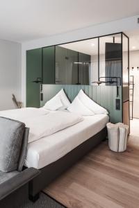 sypialnia z dużym łóżkiem z dużym lustrem w obiekcie Stadthotel Goldenes Schiff w mieście Bad Ischl
