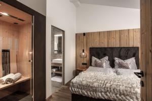 a bedroom with a large bed and a bathroom at hager's apartments in Saalbach-Hinterglemm