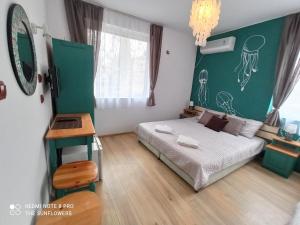 a bedroom with a bed and a table and a mirror at Guest House Sunflowers in Pomorie