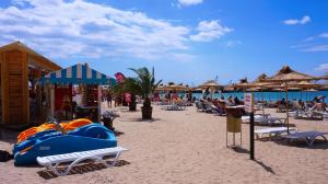 a beach with a blue boat on the sand at Вила Делфин - Villa Delfin in Bŭlgarevo