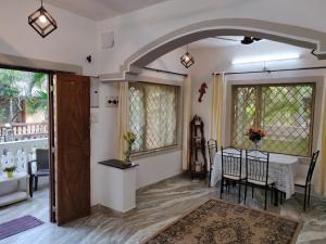 a living room with a table and a dining room at Rosean Homestay Self Service Apartments in Candolim