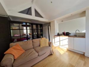 a living room with a couch and a kitchen at Maison Montana in Brussels