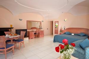 a bedroom and living room with a bed and a table at Le Querce Resort Sea Thermae & Spa in Ischia