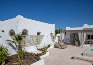 a white house with a patio and a swimming pool at DAFNES VILLA 2 in Perivolos