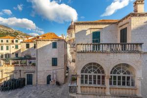 Habitación con balcón y vistas a un edificio antiguo. en Apartments Placa Dubrovnik, en Dubrovnik