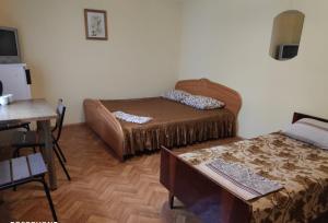Habitación con 2 camas y mesa. en Guest House U Chizhika, en Sevastopol