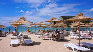 a beach with chairs and umbrellas and people on it at Вила Силва - Villa Silva in Bŭlgarevo