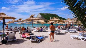 布加雷沃的住宿－Вила Силва - Villa Silva，一群人在海滩上,带椅子和遮阳伞