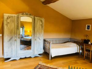 - une chambre avec un lit et un grand miroir dans l'établissement Le Fraysse, à Montdurausse