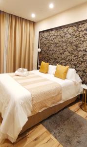 a bedroom with a large white bed with yellow pillows at Casa Balmes in Barcelona