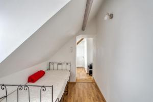 ein Schlafzimmer mit einem Bett mit einem roten Kissen darauf in der Unterkunft Maison de 3 chambres avec jardin amenage a Saint Marcouf in Saint-Marcouf