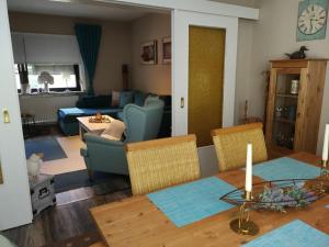 een woonkamer met een tafel en een blauwe bank bij Casa Carlotta - keine Monteure in Langelsheim