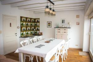 una sala da pranzo bianca con tavolo e sedie bianchi di Huis van de Koekuit a Moorslede