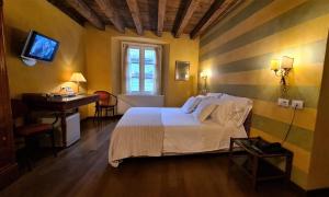Hotel Piazza Vecchia في بيرغامو: غرفة نوم بسرير ومكتب وتلفزيون