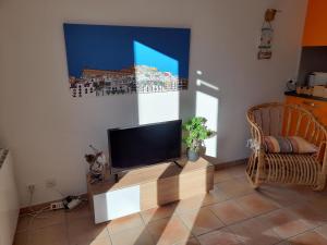 a living room with a flat screen tv and a chair at Villa Diego in Castelnau-le-Lez