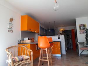 a kitchen with orange cabinets and an orange stool at Villa Diego in Castelnau-le-Lez