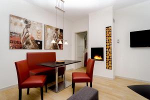 a living room with a table and chairs and a fireplace at Ostseedomizil La Mer in Börgerende-Rethwisch