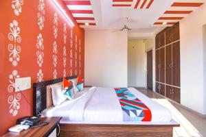 a bedroom with a large bed and a desk at FabExpress Bzoie Heritage in Dehradun