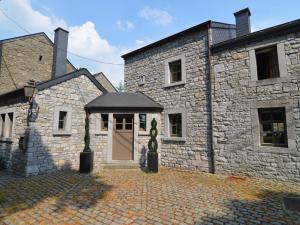 uma casa de pedra com uma porta e um pátio em between town of Spa and Durbuy a lovely cottage em Hamoir