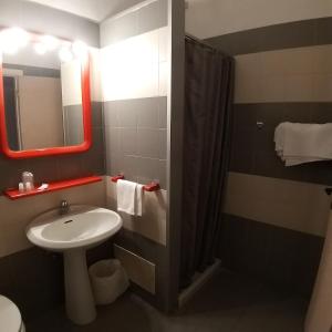 uma casa de banho com um lavatório, um WC e um espelho. em Cavalieri del Tau em Altopascio