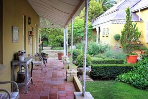 patio ze stołem, krzesłami i roślinami w obiekcie Roche House w mieście Queenstown