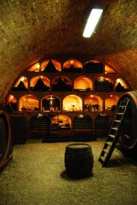 a wine cellar with a barrel and a shelf of wine bottles at Sipos Borház és Vendégház in Badacsonyörs