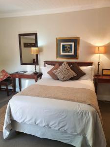 a bedroom with a large bed with two lamps and a desk at Roche House in Queenstown