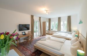 um quarto de hotel com duas camas e uma secretária em guenstigschlafen24 – die günstige Alternative zum Hotel em Munique