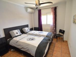 a bedroom with a bed and a chair and a window at Superb villa for large families with large pool in San Fulgencio in La Marina