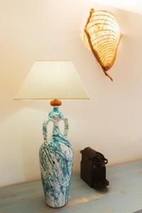 un vaso blu e bianco con una lampada sul tavolo di Echi di Puglia Marsento a Polignano a Mare
