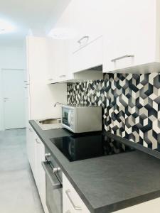 a kitchen with white cabinets and a microwave on a counter at B&B Da Jana in Pordenone