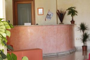 a lobby with a reception counter with potted plants at HOTEL COSTA ANTIGA in SantʼAnna Arresi