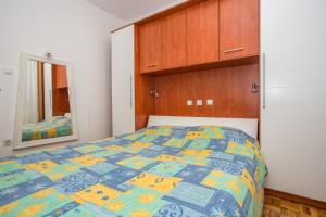 sypialnia z łóżkiem z niebieską i żółtą kołdrą w obiekcie Antonija i Ante w mieście Kampor