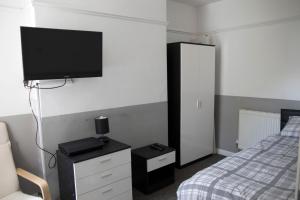 a bedroom with a bed and a flat screen tv on the wall at Bursar Street 19 in Cleethorpes +5 photos