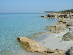 une plage avec des rochers et l'océan par beau temps dans l'établissement HOTEL COSTA ANTIGA, à SantʼAnna Arresi