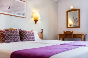 a bedroom with a bed with purple sheets and a mirror at Inturotel Azul Garden in Cala d´Or