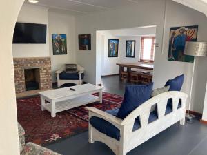 sala de estar con sofá y chimenea en Hermanus Backpackers & Budget Accommodation, en Hermanus