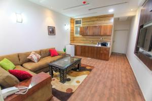 uma sala de estar com um sofá e uma mesa em سكنا للشقق الفندقية em Buraydah